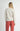 Back view of model wearing Irisha oatmeal diamond pointelle sweater with red pants