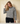 Round neck long-sleeve stripe sweater worn by a model with long hair against a neutral background.