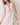 Model wearing a Floral Print Sleeveless Tiered Babydoll Dress with pink floral design and split V-neckline.