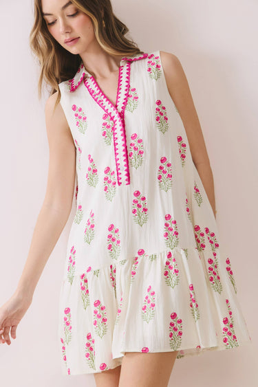 Model wearing a Floral Print Sleeveless Tiered Babydoll Dress with pink floral design and split V-neckline.