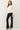 Side view of model wearing white long sleeve top with black pants