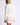 Full-length view of model wearing white Chiara long-sleeve pullover sweater