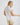 White collared V neck button down line lace detail shirt with beige shorts, front view