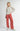 Front three-quarter view of model wearing Irisha oatmeal diamond pointelle sweater with red pants