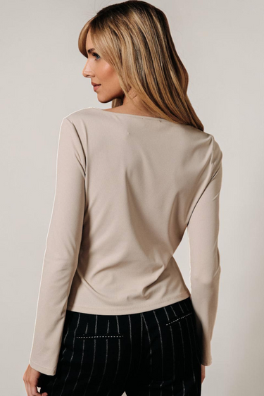 Back view of model wearing white Boat Neck Semi Bell Long Sleeve Knit Top with black pants