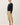 Side view of model wearing black short sleeve top