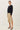 Side view of model wearing black short sleeve top