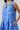 Kaidy Tropical Loly Trapeze Mini Dress featuring a blue ruffle trim split neckline and pockets.