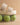 The Polly Cream Ruffle Strap Raffia Platform Slide Sandal placed on a net with green apples, showcasing its stylish design.
