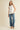 Model wearing Pleated throughout Sleeveless A Line Top with textured finish and pleated hem, paired with wide-leg jeans.