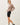 Side view of model wearing stone cotton modal fleece sweatshirt with black shorts