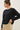 Model wearing black short sleeve top