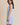 Light blue boat neck sleeveless side tie mini dress worn by a model, side view.