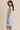 Light blue boat neck sleeveless side tie mini dress worn by a model, side view.