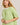 Close-up view of model wearing green short sleeve sweater cardigan