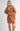 Front view of model wearing Elianna rust wide collar cardigan with shorts