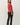 Back view of model wearing red raglan sleeve pullover sweater with black pants