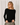 Model wearing black Boat Neck Semi Bell Long Sleeve Knit Top with casual pants