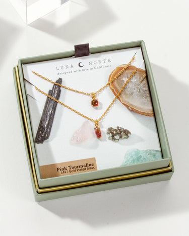 Four Letter Word Necklace - Pink Tourmaline in a gift box with crystals, showcasing the double strand design.