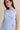 Close-up of a model wearing a light blue boat neck sleeveless side tie mini dress.