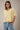 Model wearing yellow short sleeve sweater cardigan with jeans