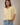 Model wearing yellow short sleeve sweater cardigan with jeans