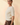 Side view of model wearing cream ribbed knit top with brown pants