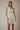 Model wearing a V NECK BUTTON UP SLEEVELESS PRINT DRESS in light green with a pattern, displaying casual summer style.