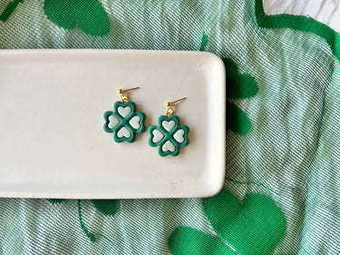 Two Tone Shamrock Earrings Clover Clay Earrings displayed on a white plate with a green background.