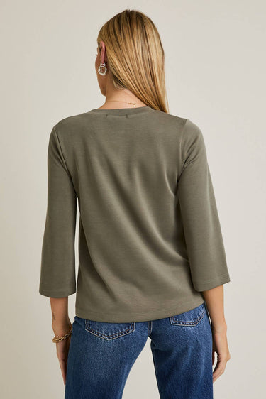 Back view of model wearing olive green Round Neck 3-4 Sleeve Top with blue jeans