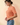 Side view of model wearing orange Round Neck Puff Short Sleeve Cable Sweater with blue jeans