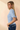 Side view of model wearing blue Round Neck Puff Short Sleeve Cable Sweater with blue jeans