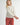 Front view of model wearing Irisha oatmeal diamond pointelle sweater with red pants