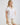 Back view of white collared V neck button down line lace detail shirt with beige shorts
