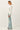 Side view of model wearing light-colored raglan sleeve pullover sweater with jeans