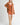 Front view of model wearing Elianna rust wide collar cardigan with white shorts