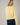 Back view of model wearing yellow Round Rolled Hemline Detail Thin Sweater Cardigan with navy shorts