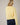 Back view of model wearing yellow Round Rolled Hemline Detail Thin Sweater Cardigan with navy shorts