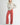 Front view of model wearing Irisha oatmeal diamond pointelle sweater with red pants