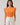 Model wearing Donna Dot Hessi Button Down Top with floral print and ruffled cap sleeves in vibrant orange.