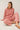 Model wearing pink cotton modal fleece sweatshirt, seated pose