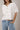 Model wearing white short sleeve sweater cardigan with jeans