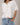 Model wearing white short sleeve sweater cardigan with jeans