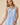 V-neck Baby doll Sleeveless Blouse with Ruffle Top worn by model in light blue, featuring ruffle detail and button closure.