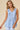 V-neck Baby doll Sleeveless Blouse with Ruffle Top worn by model in light blue, featuring ruffle detail and button closure.