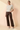 Full-length view of model wearing cream ribbed knit top with brown pants