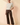 Full-length view of model wearing cream ribbed knit top with brown pants