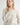Close-up of model wearing Irisha Diamond Pointelle Sweater in Oatmeal,