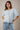 Model wearing light blue short sleeve sweater cardigan