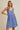 Model wearing SURPLICE S.P.G STRAP FALRE HEM DITSY MINI DRESS in blue floral print, perfect for casual outings.